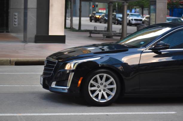  A black Cadillac sedan is parked on the street, highlighting its elegance and suitability for limousine rentals near me.
