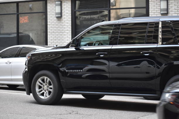 . A black Cadillac sedan parked on the street, representing a stylish option for those seeking limousine rental services.