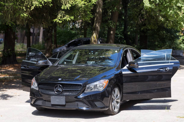 A parking lot filled with a row of cars, including limousines from a rental service.