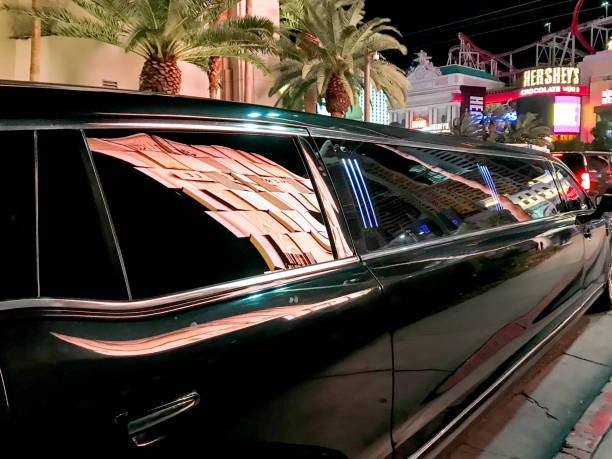 A black limousine labeled 'Private Limo' parked on the street at night, illuminated by nearby streetlights.
