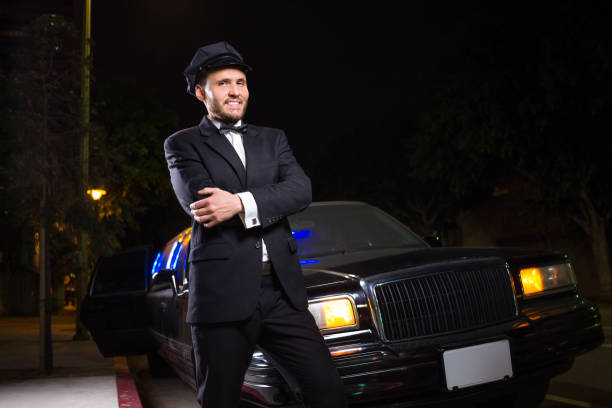  A man in a suit and tie stands beside a private limo, ready for an event or formal occasion.