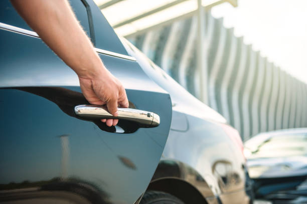 A person opens the door handle of a black car from Right Black Car Rental Service.
